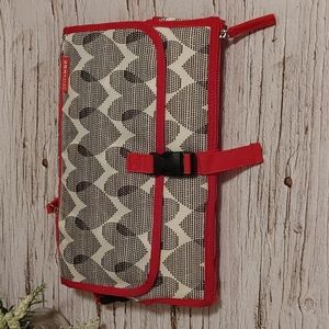 SkipHop  Diaper change pad with storage red black and grey pattern